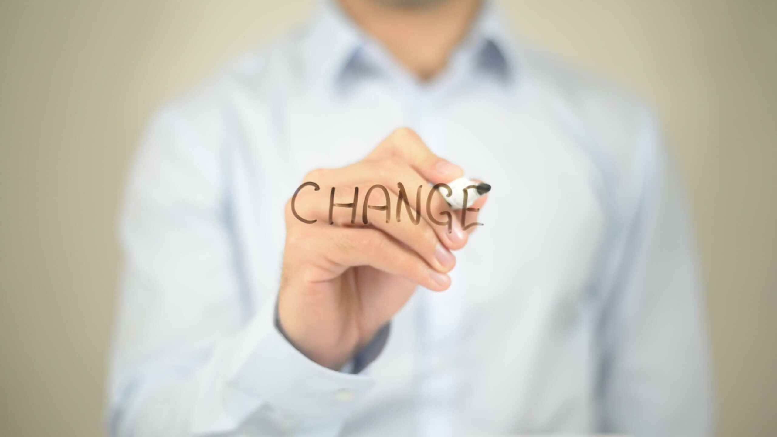 uomo che scrive su vetro la parola change con pennarello